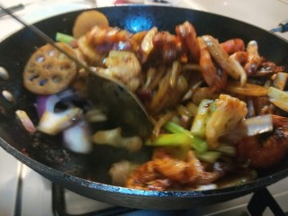 26、麻辣干锅虾,倒入土豆，藕片。倒入洋葱芹菜炒均匀即可出锅。