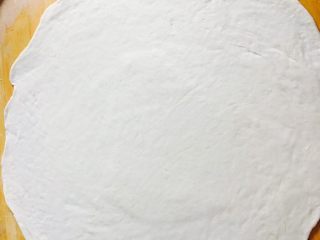 12、美味酱香饼,将面团按扁再次擀薄擀大一点饼铛内可以出一些褶皱