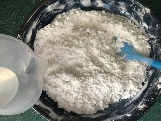 3、炒元宵,再少量多次加入室温水，边加边搅拌，70克不一定全加完，能成团即可