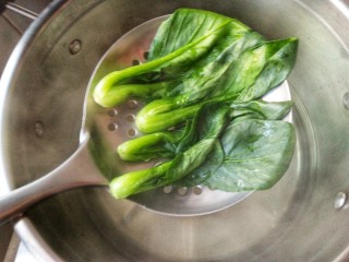 4、腊味煲仔饭,将焯熟的油菜沥水捞出备用。