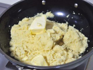 6、绿豆糕,取一个不粘锅,倒入绿豆泥和黄油,不停翻炒让绿豆泥完全吸收油分,全程用小火。