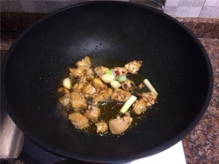 6、四宝烧鸡翅,放入葱头大蒜翻炒10秒。