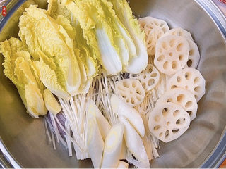 10、部队火锅,把洗干净的娃娃菜和莲藕、大葱铺好