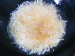2、干煸土豆丝,锅中倒入适量油，六七成热时倒入土豆丝开始炸，中途要用筷子不断翻拨；（量多可分多次炸，我分两次炸的）