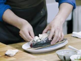 5、梅香咸鱼蒸鲈鱼&腊味双拼饭 ,将鲈鱼用筷子与盘子隔开,将咸鱼切片铺在鲈鱼肚子上