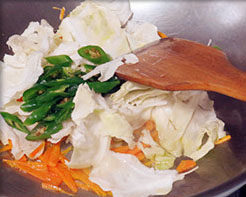 6、韩式辣炒年糕,然后下包菜、辣椒翻炒片刻