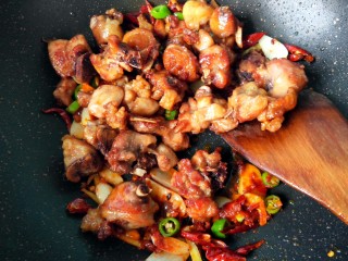 15、干煸辣子鸡丁,倒入鸡丁，半勺白糖翻炒。。