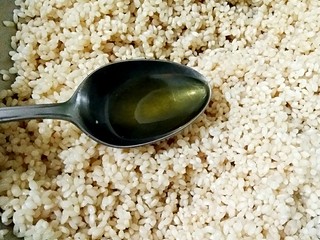 6、鲜肉粽子,在拌匀汤汁的糯米中再加入1勺香油。