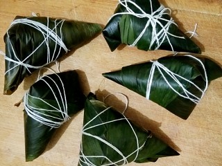 11、鲜肉粽子,用棉线绳将粽子五花大绑起来，我绑的实在是有点丑哈。但是粽子包出来好不好吃和系的紧不紧很有关系。所以还是尽量多绑几下，绑紧。