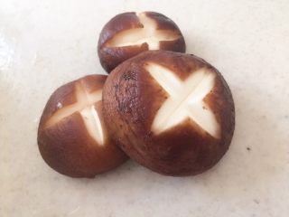 4、#辣味#串串香麻辣火锅,香菇洗净泥沙，去根，在表面划上十字刀。