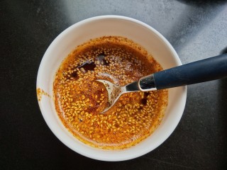 6、自制饺子蘸料（附辣椒油的制作方法）,烧至油微微冒烟，将油淋入碗中，用勺快速搅拌均匀，辣椒油就做好了（我是用汤勺把油分三次舀入碗中，辣椒粉发出滋滋的声音，这样红油就出来了）。