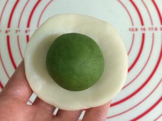 10、四色螺旋蛋黄酥,取一份油皮，用手按扁，放上一份油酥。