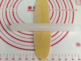 17、四色螺旋蛋黄酥,取一份静置好的油酥皮，用手压扁，用擀面杖再一次从中间往两头擀开。