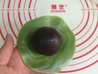 22、四色螺旋蛋黄酥,把擀开的面皮翻个面，有纹理的那面朝下，放上一枚馅料。