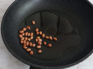 4、美味酸辣粉,放入花生米,小火煎炸。