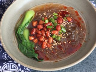 11、美味酸辣粉,煮好的红薯粉捞入碗中,放入油炸花生米、小油菜,葱花碎、撒一勺芝麻,淋上调好的料汁,再浇上煮红薯粉的汤即可。