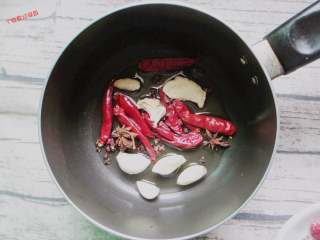 9、钵钵鸡,接着我们再来炒个底料，炒锅倒油烧热，放入红辣椒，香叶，花椒，葱段，蒜瓣和姜片，炒出香味。