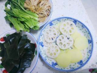 2、火锅鱼,锅里烧水将藕土豆海菜金针菇等（除了青叶菜）焯水一下捞出沥水备用。