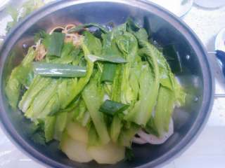 7、火锅鱼,上面铺上青叶菜和几根大葱叶和芹菜叶段。