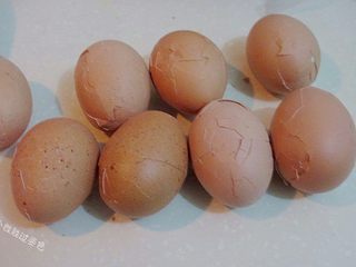3、龙猫茶叶蛋,待表皮冷却后,用双手各拿起一个鸡蛋,相互敲击,使鸡蛋的外壳形成裂纹。(也可以彻底去皮)