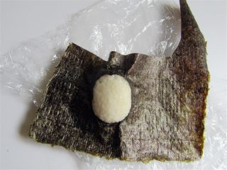 5、可爱的企鹅饭团,把镂空地方对准米饭团包起来