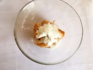 7、Q弹土豆丸子,淀粉碗里放入土豆泥、面粉用手抓拌均匀；