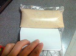 4、香酥虾滑,取一部分打好的虾滑装进保鲜袋中，用塑料刮板将虾滑推紧实，冷冻成型