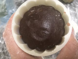 8、广式巧克力莲蓉月饼,取一个面团放入模具内压紧压平