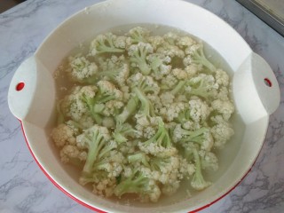 1、肉炒菜花,菜花掰成小块，放在盐水中浸泡20分钟，再多清洗几遍