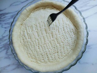 6、独家秘方披萨,用叉子扎满洞洞,防止饼皮烤的过程中,中间凸起。放入烤箱进行二次发酵约15分钟左右。