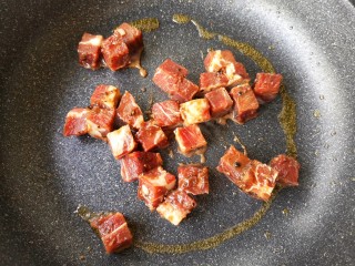 8、彩椒牛肉粒,锅中留适量底油，放入腌制好的牛肉粒，大火爆炒。