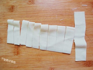 2、豆皮卷金针菇,豆腐皮用刀切成长条