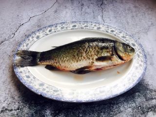 1、鲫鱼豆腐汤,鲫鱼1条,约400g重。 鲫鱼先刮去鱼鳞,去除内脏和腮,剪去鱼鳍鱼尾,然后仔细清洗干净,尤其是内脏部位要多清洗一下。 沥干水分备用(可用厨房用纸吸干水分)。