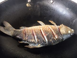 3、鲫鱼豆腐汤,当鱼的一面煎至金黄色时翻过来再煎另一面,两面都煎至金黄色就OK了。 温馨提示,当把鱼刚刚放到锅里后千万不要急于翻动,如果翻动了,肯定会粘锅的,因为油很热,鱼和铲子都是凉的,热油一下子就会“抱住”铲子和鱼,肯定会粘锅。那么我们什么时候才能翻动鱼呢,1,中火煎制至少1分钟后才能翻动。2,还有就是被煎鱼的那面两边会有明显的金黄色才可以翻动。3,再有就是当离火晃动锅时,鱼可随意在锅里滑动也可以翻动。建议初学者用第2种方法判断。 温馨提示,如果小伙伴选择的是大条的鱼,在翻动鱼时请用两把铲子翻动。