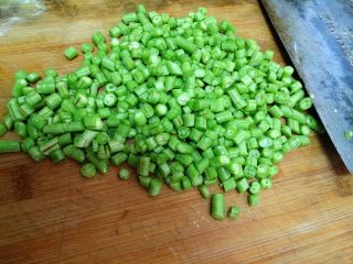 2、豆角煲仔饭,把豆角洗净，改刀成小粒状。