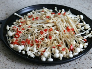 9、蒜蓉金针菇烤花蛤虾,把腌制虾的酱汁倒在金针菇上，浇上一勺蒜末油