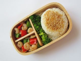 14、小熊奶酪包饭趣味便当,将饭菜整齐码放在饭盒中，饭团上部用炒菜的菜汁涂抹下
