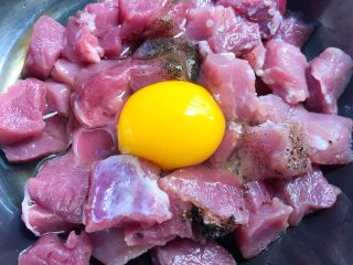 5、菠萝咕噜肉,里脊肉放入碗里，加入1g盐、1g黑胡椒粉、10g料酒，打入1个鸡蛋，搅拌均匀腌制5分钟