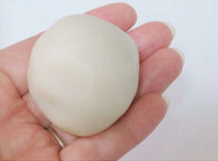 7、冰皮豆沙月饼,在手上拍点糕粉防粘，将冰皮放在手心压扁，放上一块月饼馅，包好