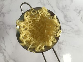 3、鲜虾脆面盏,把面条铺在漏勺里，成碗状。