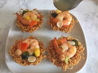 11、鲜虾脆面盏,把煮好的浇头盛入面盏中，淋上汤汁。