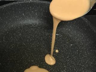 5、胡萝卜小饼,热锅刷油，开小火，舀一勺面糊，自上而下倒入，面糊自动成圆形。待定形