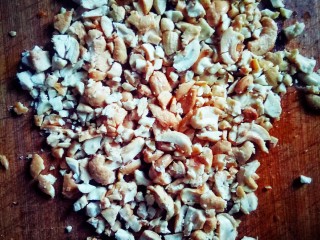 6、坚果牛肉香辣酱,用擀面杖把花生米和腰果压碎。