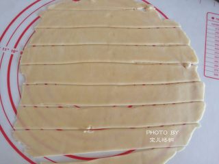 6、苹果玫瑰卷,然后拿出来，擀平，用刮刀分成相等大小的长条