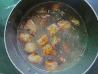 9、秘制鹌鹑蛋红烧肉,翻炒均匀后，加热水没过五花肉，加入老抽调色。加入料酒，大火烧沸转中小火炖煮