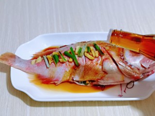 6、#年年有鱼#红烧红石斑,均匀淋上蒸鱼豉油,按个人口味撒上盐,腌制30分钟。