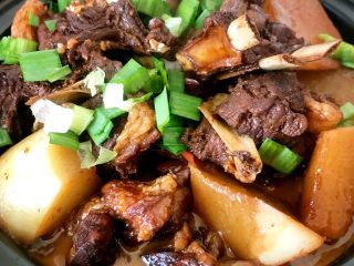 13、红烧羊排炖萝卜小火锅,点燃酒精煲，羊排盖上盖子再次烧开，撒上大蒜叶子即可一家人围绕着餐桌慢慢享用这热气腾腾的羊排萝卜小火锅