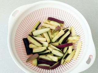 2、避风塘茄子,切成条，放入5克盐腌制出汁，在攥掉茄子里面的多余水分。