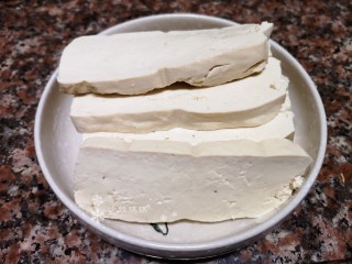 4、韭菜炒豆腐,将豆腐切成约1厘米厚的片状。