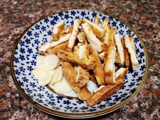 7、韭菜炒豆腐,将油豆腐切条，大蒜切片。